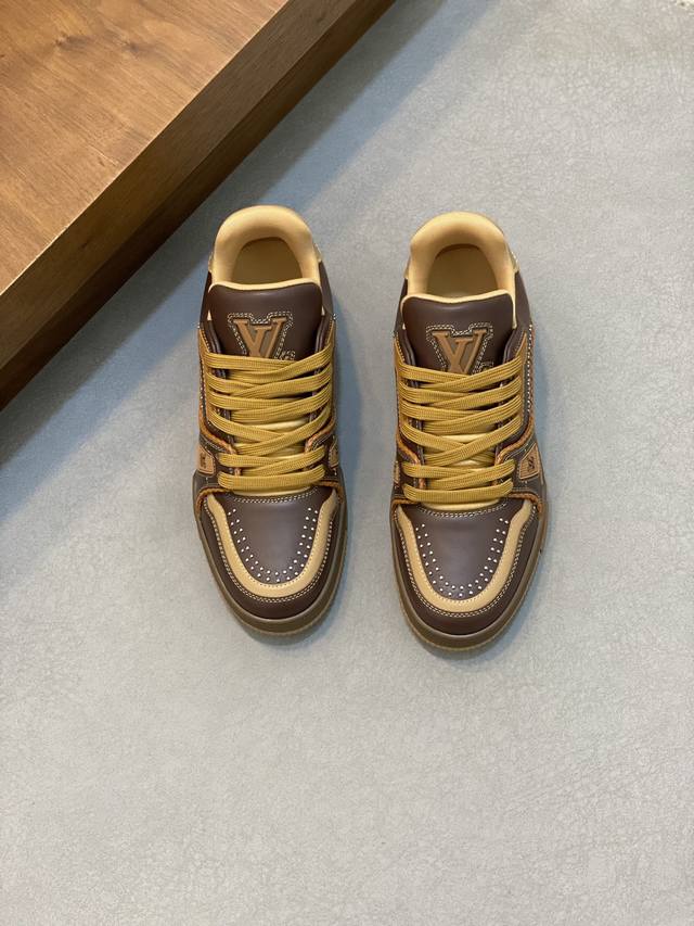 Lv Trainer 男士运动鞋，全新配色，本款 Lv Trainer 运动鞋为粒面牛皮革渲染缤纷色调，鞋面点缀铆钉装饰，侧面点缀手写体路易威登标识，与后部西部