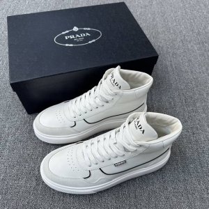 prada 普拉达 男士新款高帮皮革休闲运动鞋 这款高帮运动鞋采用光滑小牛皮鞋面，鞋头及后跟辅以绒面牛皮革细节，撞色皮革饰边，外侧饰有品牌徽章，鞋舌饰prada