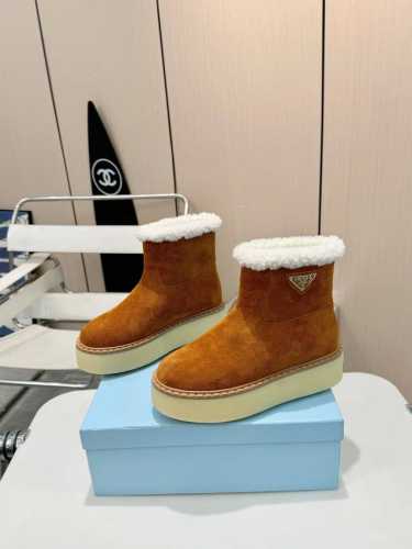 Prada 厚底雪地靴，时尚与温暖并存。 经典三角标，彰显品牌魅力。内里和垫脚全羊毛，保暖效果满分，让你在寒冷冬日也能暖意融融。4 厘米厚的 Tpu 鞋底，增高