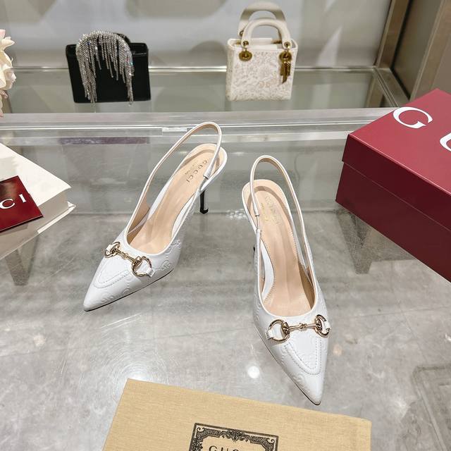 2024-6* 白￥390（35-41）这款优雅的露跟高跟鞋甄选白色Gg皮革匠心制作，颇具辨识感的品牌元素马衔扣为鞋履中央增添亮眼点缀。尖形鞋头搭配松紧系带，高