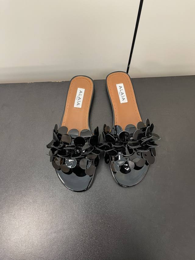 Alaia 阿莱亚花朵缀饰平底拖鞋！ 无数的名设计师都把他看作“Designerofdesigners”更影响着很多人的风格！铆钉、金属环扣、紧束胸衣和性感蛇皮