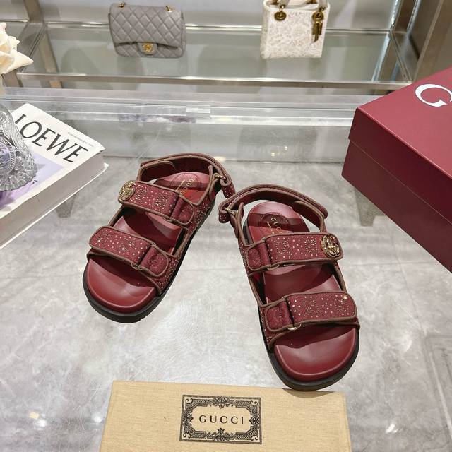 8818-5 酒红G钻 35-42 这款平底凉鞋采用魔术粘带设计，现代感十足且充满运动气息，带来舒适感受。这款配饰以安哥拉红色Gg水晶帆布匠心打造，鞋面绑带缀饰