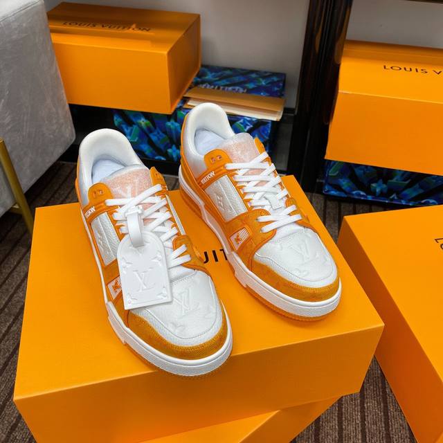 本款 Lv Trainer 运动鞋取材 Monogram 压纹粒面小牛皮和丝滑小牛皮饰边，展现路易威登男装艺术总监 Virgil Abloh 对复古篮球鞋的灵感
