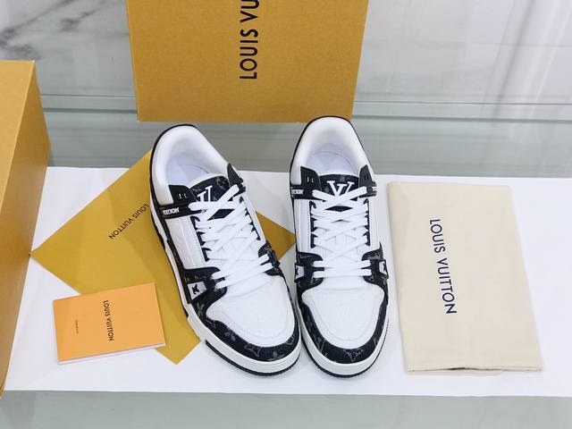 本款 Lv Trainer 运动鞋取材 Monogram 压纹粒面小牛皮和丝滑小牛皮饰边，展现路易威登男装艺术总监 Virgil Abloh 对复古篮球鞋的灵感