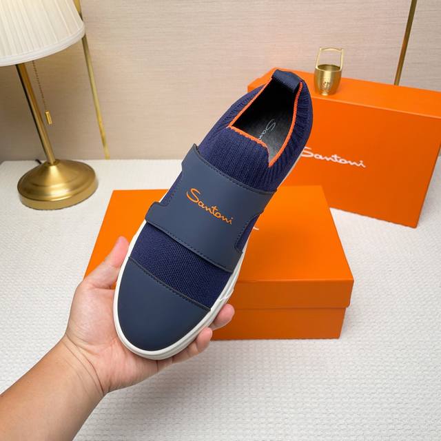 Santoni 圣东尼 这是一款男士低帮运动鞋，由意大利制造。 材质与构造：采用进口飞织拼接皮制作，未加内衬且解 构设计，呈现简约风格。 颜色与细节：鞋身为黑色