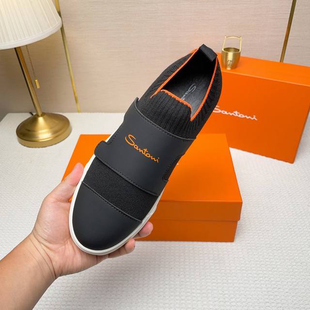 Santoni 圣东尼 这是一款男士低帮运动鞋，由意大利制造。 材质与构造：采用进口飞织拼接皮制作，未加内衬且解 构设计，呈现简约风格。 颜色与细节：鞋身为黑色