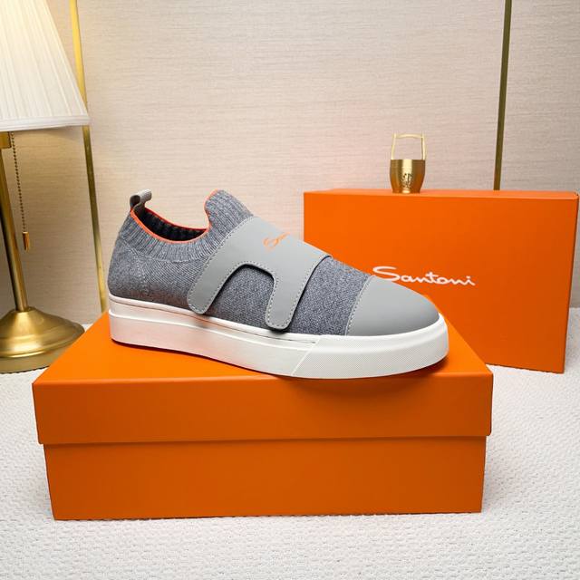 Santoni 圣东尼 这是一款男士低帮运动鞋，由意大利制造。 材质与构造：采用进口飞织拼接皮制作，未加内衬且解 构设计，呈现简约风格。 颜色与细节：鞋身为黑色
