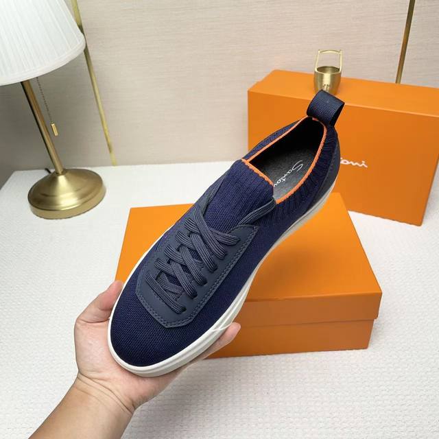 Santoni 圣东尼 这是一款男士低帮运动鞋，由意大利制造。 材质与构造：采用进口飞织拼接皮制作，未加内衬且解 构设计，呈现简约风格。 颜色与细节：鞋身为黑色