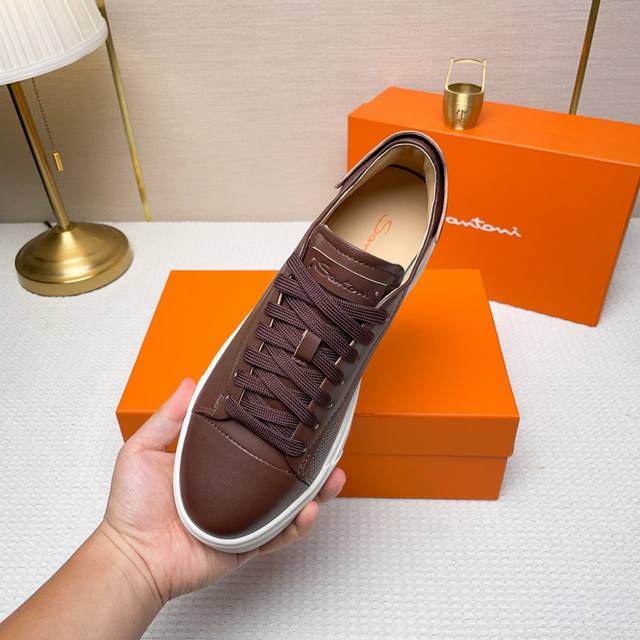 Santoni 圣东尼 这是一款男士低帮运动鞋，由意大利制造。 材质与构造：采用进口牛皮制作，未加内衬且解 构设计，呈现简约风格。 颜色与细节：鞋身为黑色，鞋舌