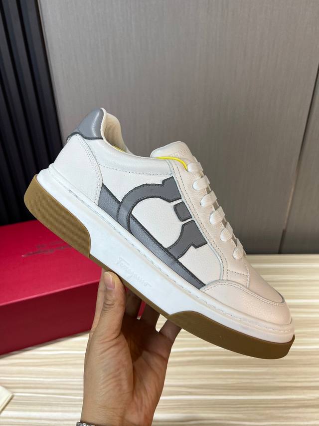 Ferragamo 菲拉格慕 新款男士Gancini轮廓低帮休闲鞋，这款低帮休闲鞋选用麂皮及小牛皮皮革制造。其灵感源自九十年代篮球鞋风格，侧面Gancini嵌饰