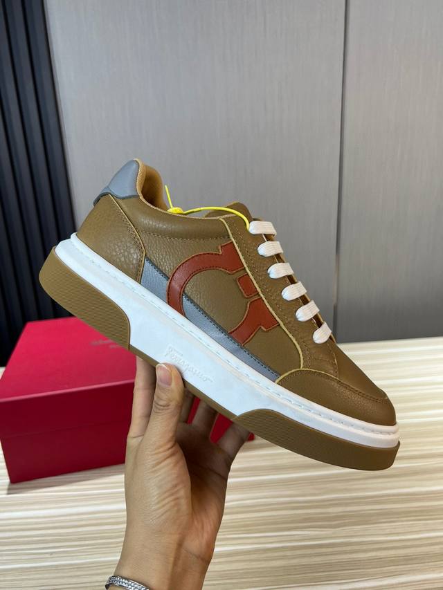 Ferragamo 菲拉格慕 新款男士Gancini轮廓低帮休闲鞋，这款低帮休闲鞋选用麂皮及小牛皮皮革制造。其灵感源自九十年代篮球鞋风格，侧面Gancini嵌饰