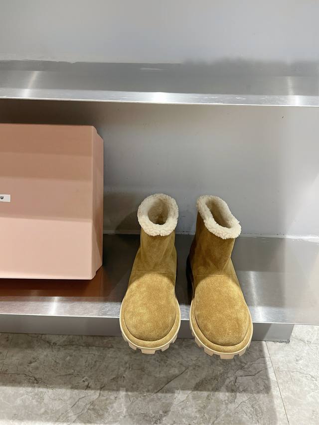 Miumiu雪地靴羊毛里短靴 这款羊羔毛里雪地靴，兼具舒适质感与冬日气息。鞋带营造出精致的视觉对比效果，为整体造型增添标志性元素。 鞋面：牛反绒 内里：羊羔毛内