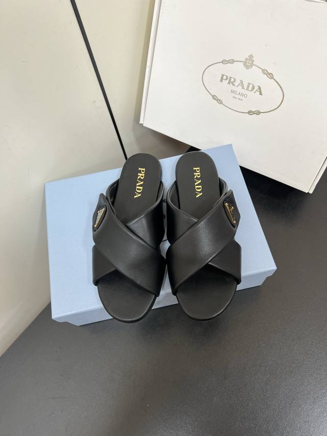Prada 普拉达三角标Nappa羊皮拖鞋交叉带平底凉拖鞋 这款拖鞋演绎精致百搭风尚，采用填充效果的Nappa羊皮革制成，烘托简洁、现代的设计线条。饰有涂珐琅三
