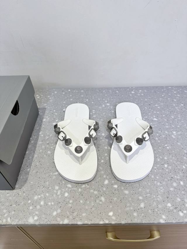 Balenciaga 巴黎世家 25Ss春夏新款 沙滩 人字拖鞋 这是一双经典的人字拖 主体由浅棕色的鞋底与黑色的鞋带构成。鞋底表面有细腻的纹理，不仅增加了与脚