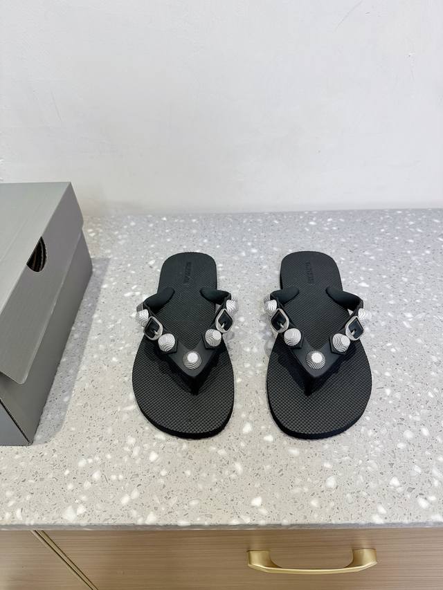 Balenciaga 巴黎世家 25Ss春夏新款 沙滩 人字拖鞋 这是一双经典的人字拖 主体由浅棕色的鞋底与黑色的鞋带构成。鞋底表面有细腻的纹理，不仅增加了与脚