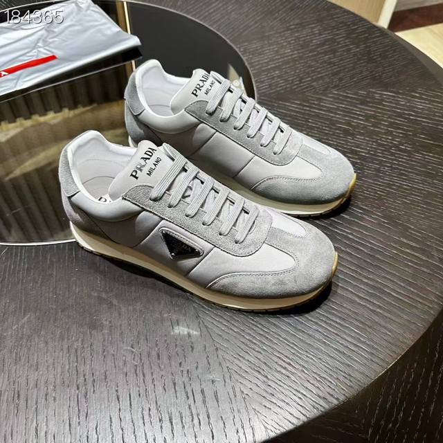 prada 复古风 这款皮革运动鞋休闲百搭，鞋底轻盈耐穿，装点标志性的涂珐琅三角形金属徽标，鞋舌饰有丝网印花徽标，彰显别具一格的魅力。 鞋面涂珐琅三角形金属徽标