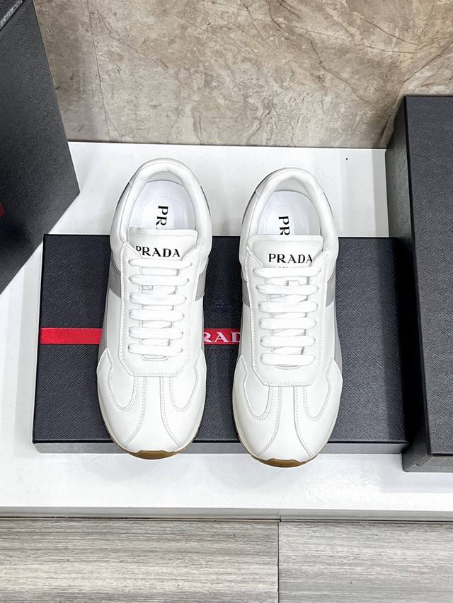 prada 普拉达 Rank皮革运动鞋这款运动鞋休闲百搭，采用柔软小牛皮制成，运用柔和简洁的线条勾勒出运动风廓形，搭配橡胶发泡中底拼接轻便的凸纹加宽橡胶鞋底，轻