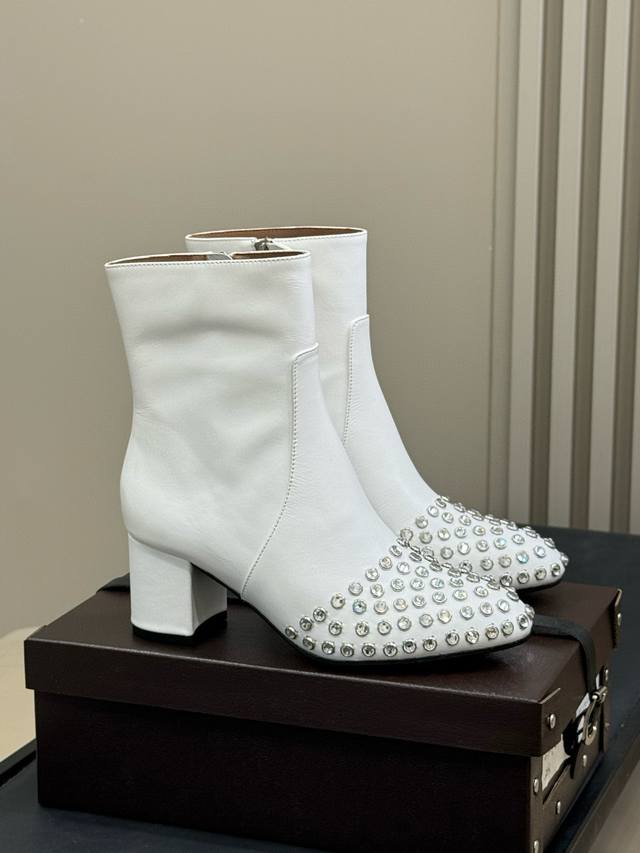 Alaia 2025秋冬新款粗跟水钻侧拉链短靴 该款黑色小牛皮高跟短靴，正面点缀装饰蝴蝶结，搭配90毫米鞋跟与22厘米靴筒；时尚百搭造型，凸显女性独特魅力！ 鞋