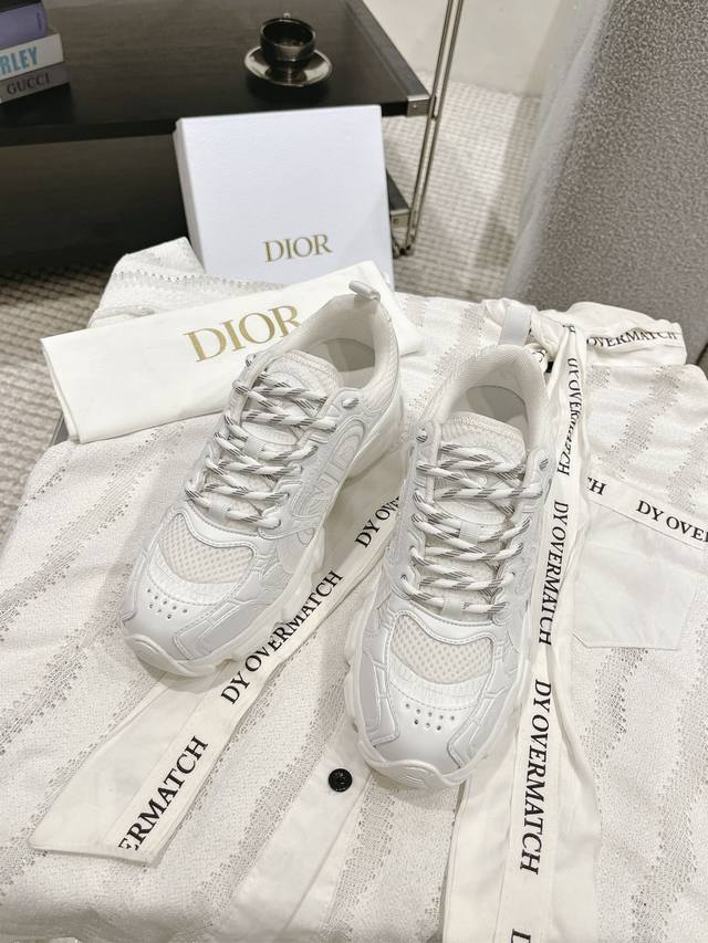 H *R 这款Dior Vibe#迪奥运动鞋融入 Di*R 的高订精神，重新诠释经典跑鞋。搭配深蓝色 Oblique 印花科技面料、网眼织物和透明橡胶镶片，打造