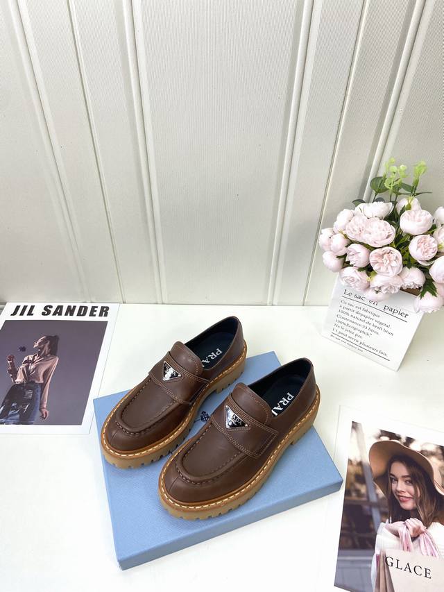 工厂p批 prada* Wa 秋冬新款厚底乐福鞋 这款皮革乐福鞋采用厚实鞋底，匠制细节与当代元素增添活力，以全新时尚语言诠释经典。 涂珐琅三角形金属徽标 高度5