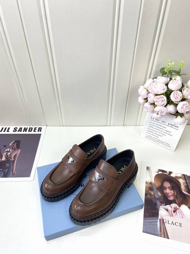 工厂 Prada* Wa 秋冬新款厚底乐福鞋 这款皮革乐福鞋采用厚实鞋底，匠制细节与当代元素增添活力，以全新时尚语言诠释经典。 涂珐琅三角形金属徽标 高度55毫