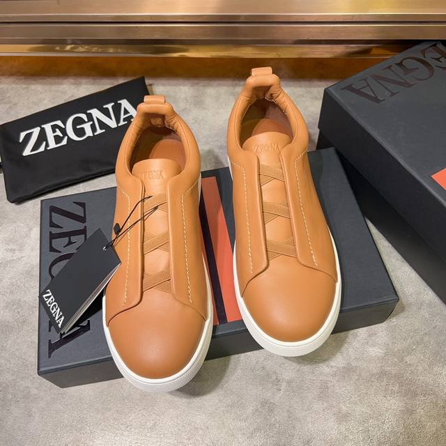 Ermenegildo Zegna 杰尼亚 光滑皮革 Tiziano 低帮运动鞋 这款tiziano 低帮运动鞋摔花纹牛皮制成，饰以丰富的工艺细节，如骆马红棕色