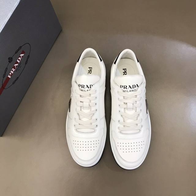 家奢品、男士时尚运动系列，这款皮革运动鞋多角度诠释pra*徽标：轻巧跃于鞋舌，沿轻质橡胶鞋底铺陈，化身橡胶三角形点缀鞋面一侧，无不阐释品牌格调。进口小牛皮材质，
