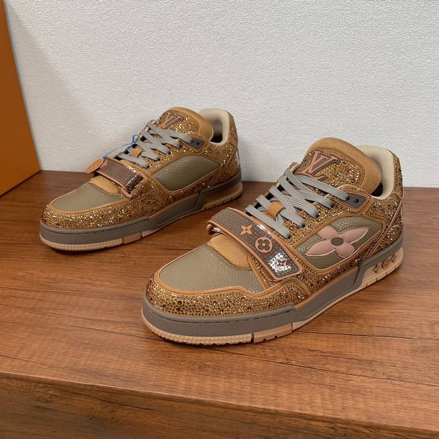 编码： Lv Trainer 情侣款镶钻运动鞋出货 本款 Lv Trainer 运动鞋以正绒面嵌入水晶和粒面牛皮革重绎 Virgil Abloh 的经典之作，再