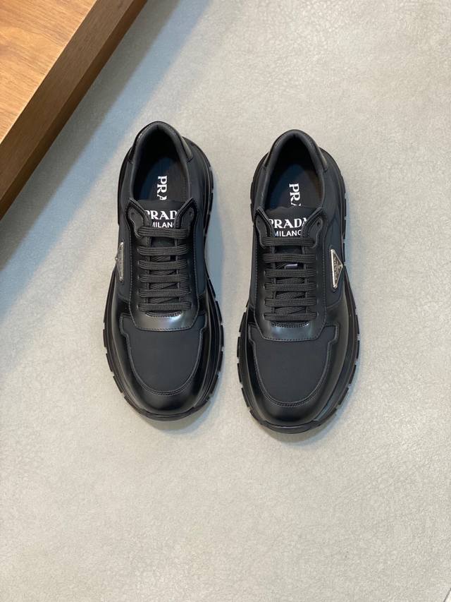 Prada 普拉达 男士新款运动休闲鞋，这款运动鞋鞋面采用进口小牛皮拼接透气网面，外侧饰以p家经典金属三角珐琅徽标，内里网布，垫脚牛皮，大底采用防滑运动专属带l