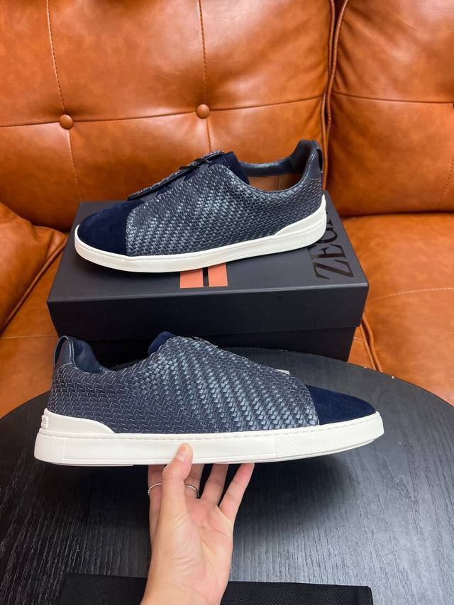 编织款！杰尼亚 休闲运动鞋这款 Triple Stitch 低帮运动鞋以柔软的牛皮搭配麂皮制成，为休闲鞋履注入精致格调。标志性三重交叉弹性细节彰显出传统皮鞋的手