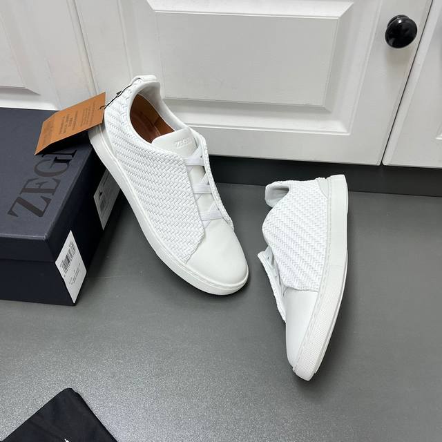 编织款！杰尼亚 休闲运动鞋这款 Triple Stitch 低帮运动鞋以柔软的牛皮搭配麂皮制成，为休闲鞋履注入精致格调。标志性三重交叉弹性细节彰显出传统皮鞋的手