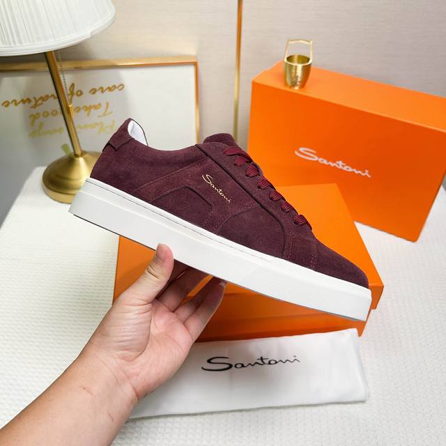 Santoni 圣东尼 这是一款男士低帮运动鞋，由意大利制造。材质与构造：采用翻毛皮制作，白色羊里，呈现简约风格。颜色与细节：鞋身为酒红色，鞋舌和鞋跟处饰有皮革