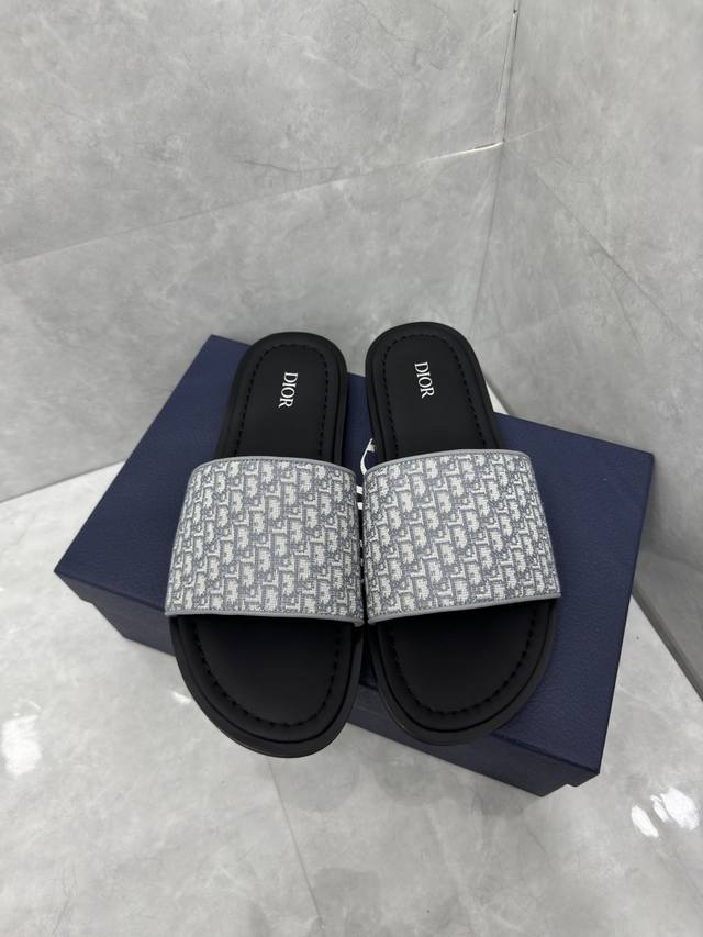 Dior Alias凉鞋是2024年新品，是一款悠闲而精致的作品。该风格采用米色和灰色Dior Oblique提花制成，展示了简单便捷设计。这款凉鞋由灰色皮革和