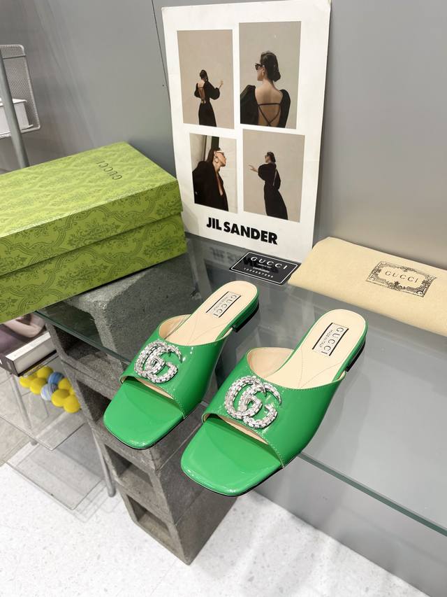 出厂： Gucci 24ss早春新款 双G水晶钻扣平底拖鞋 饰水晶双G造型配件为一系列女士鞋款注入摩登新韵。这款后系带芭蕾舞鞋以闪亮黑色漆皮匠心打造，鞋面缀饰亮