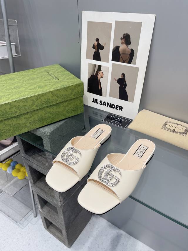 出厂： Gucci 24ss早春新款 双G水晶钻扣平底拖鞋 饰水晶双G造型配件为一系列女士鞋款注入摩登新韵。这款后系带芭蕾舞鞋以闪亮黑色漆皮匠心打造，鞋面缀饰亮