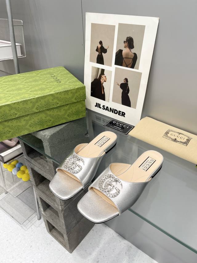 出厂： Gucci 24ss早春新款 双G水晶钻扣平底拖鞋 饰水晶双G造型配件为一系列女士鞋款注入摩登新韵。这款后系带芭蕾舞鞋以闪亮黑色漆皮匠心打造，鞋面缀饰亮