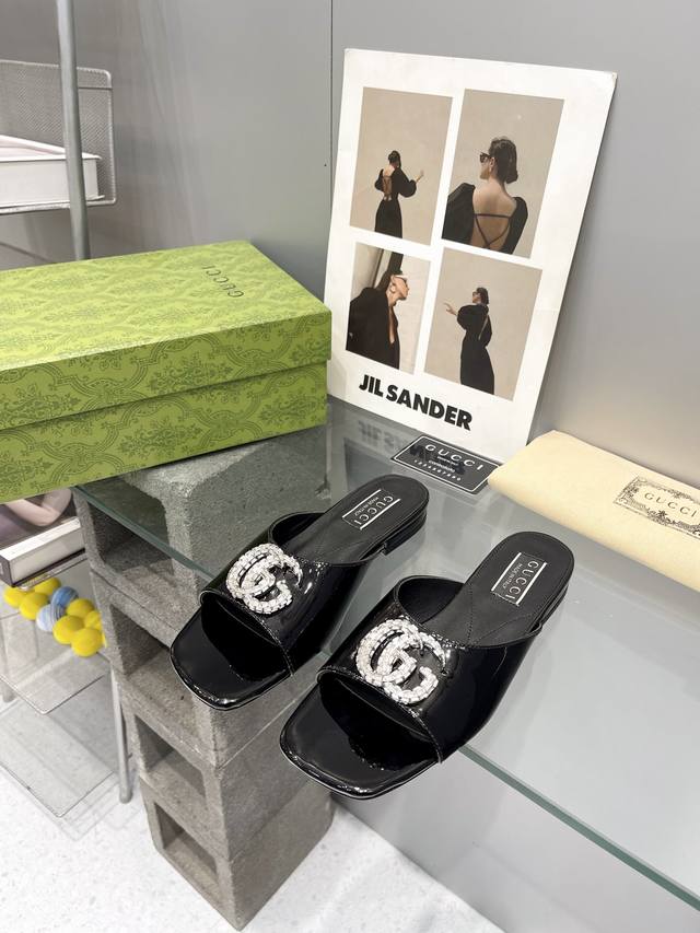 出厂： Gucci 24ss早春新款 双G水晶钻扣平底拖鞋 饰水晶双G造型配件为一系列女士鞋款注入摩登新韵。这款后系带芭蕾舞鞋以闪亮黑色漆皮匠心打造，鞋面缀饰亮